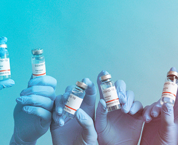 hands holding vials of COVID-19 vaccines